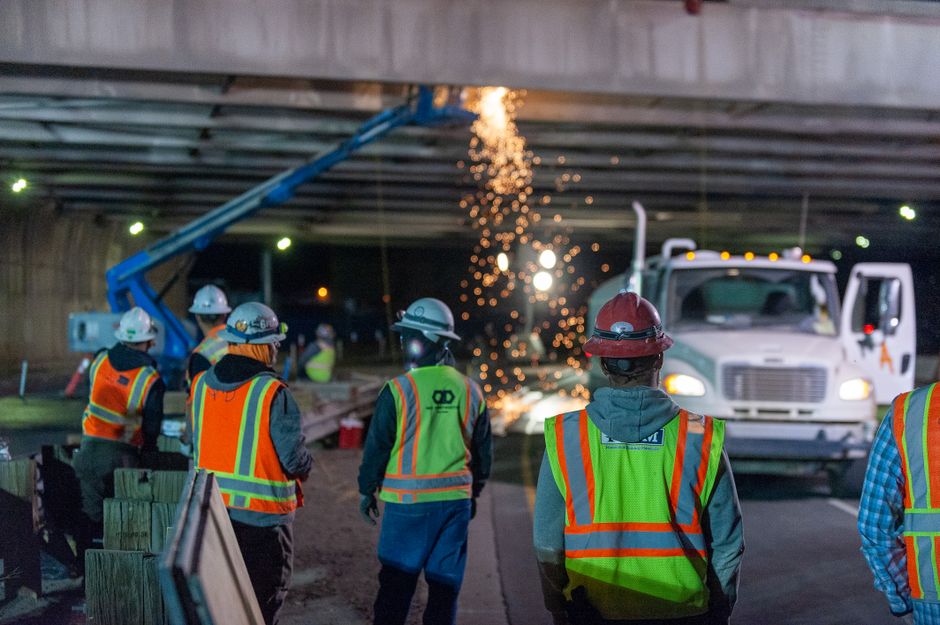 Construction crew repairing a section of an elevated highway bridge