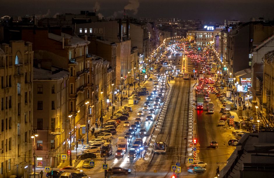 A downtown city street with nightlife venues lit up in the evening
