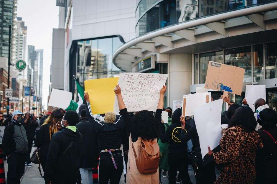 Demonstrators gather downtown holding signs during a public rally