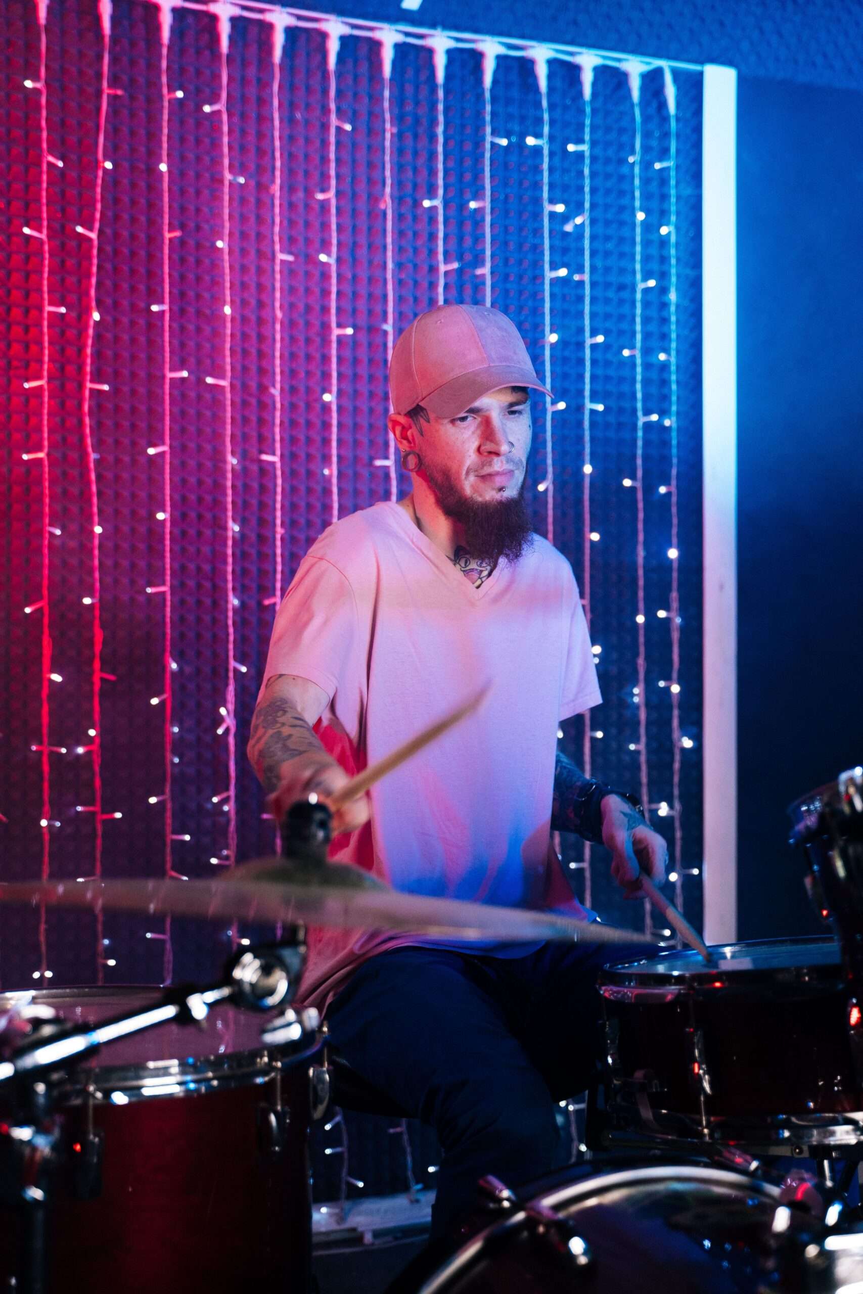 A drummer plays a full drum kit during a live performance