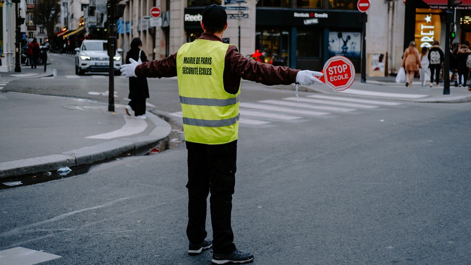 A crossing guard helps students cross a street safely