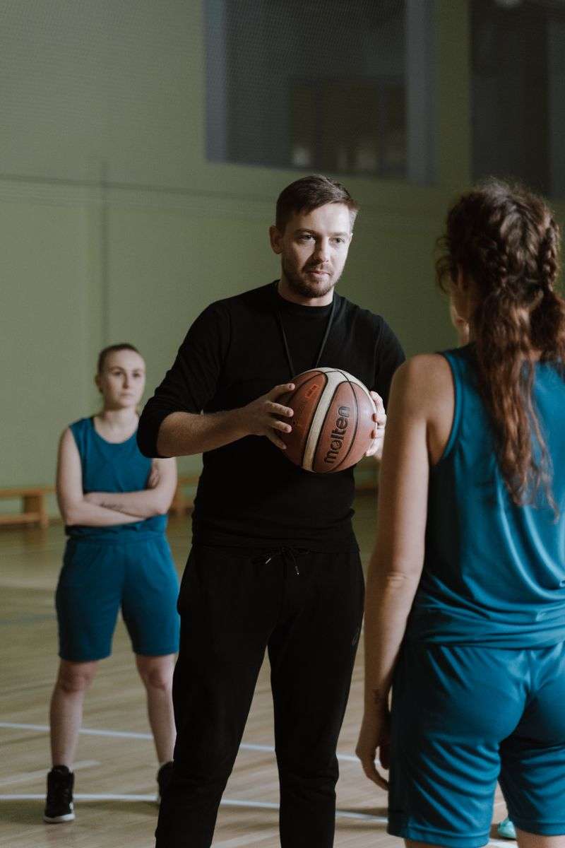 A basketball coach instructing players on the court