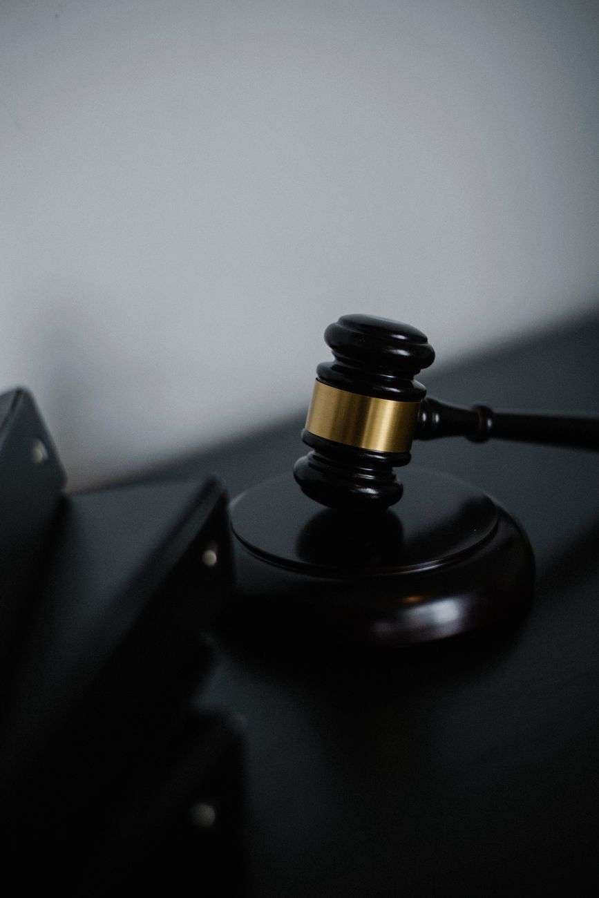 A wooden gavel resting on a desk near case files in a federal courthouse setting
