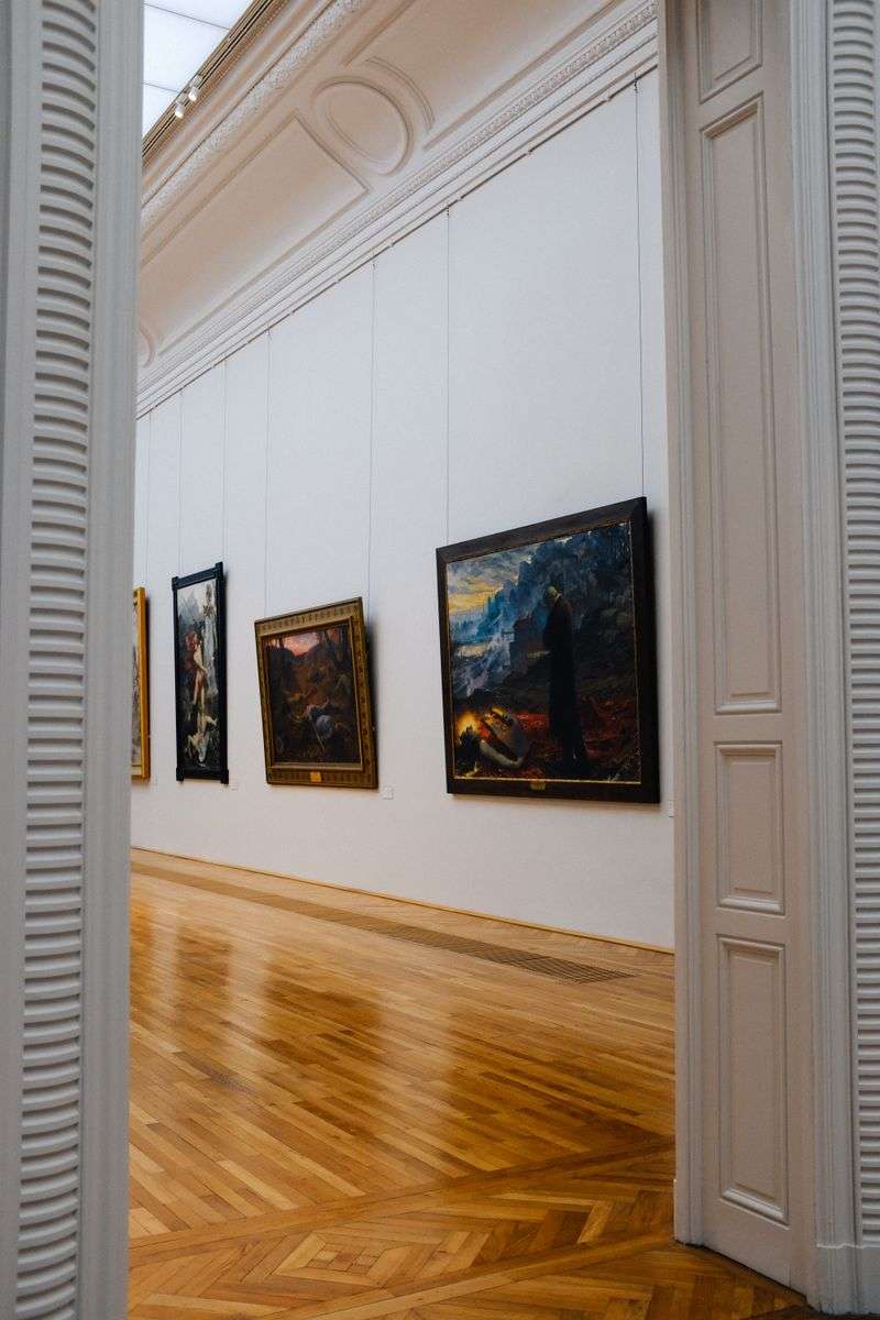 Framed artwork displayed along the walls of a modern art gallery