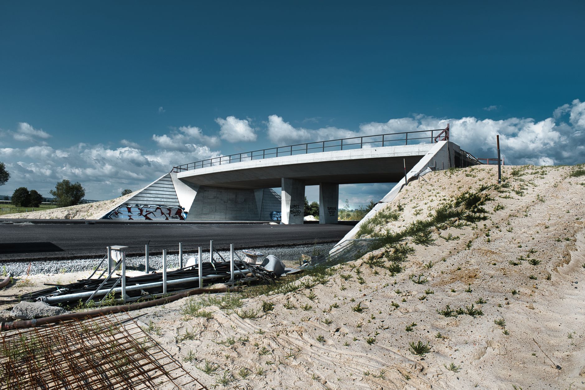 Newly poured concrete sidewalk alongside a busy roadway