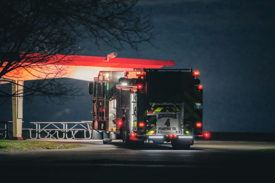 Fire trucks responding to a residential house fire at night