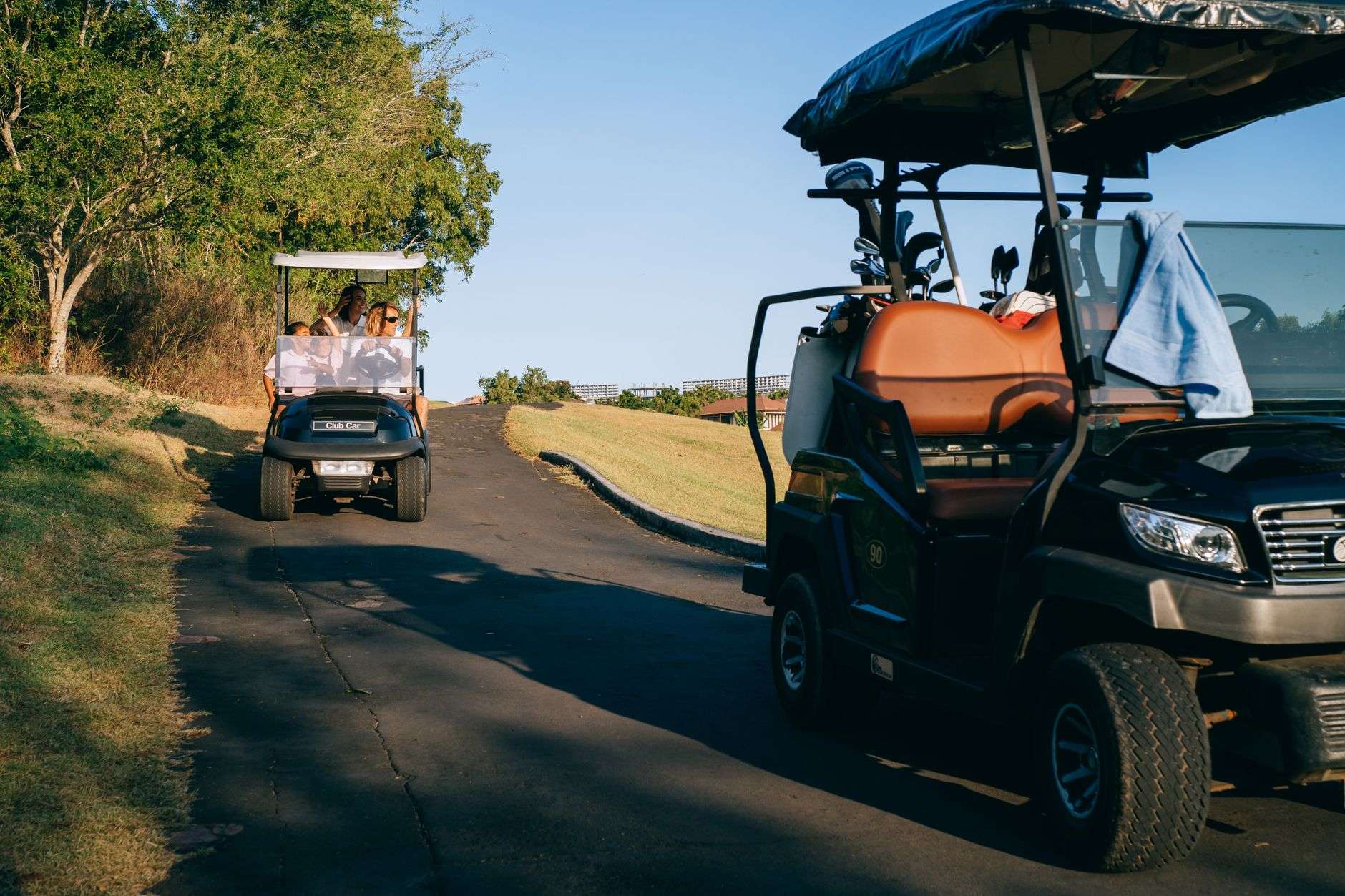 Golf carts traveling along a paved roadway