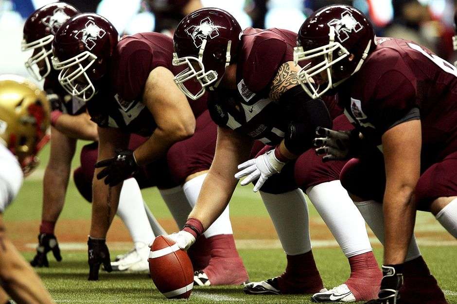 Football players line up in formation before a play
