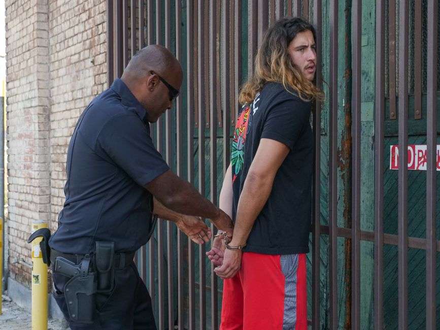 A law enforcement officer places handcuffs on a suspect during an arrest