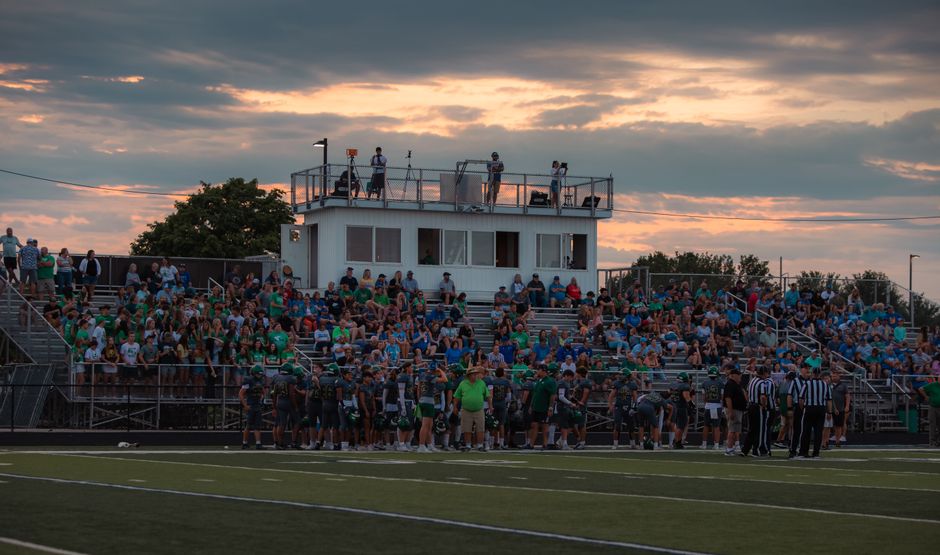 Empty high school football field representing a community remembering a shooting victim