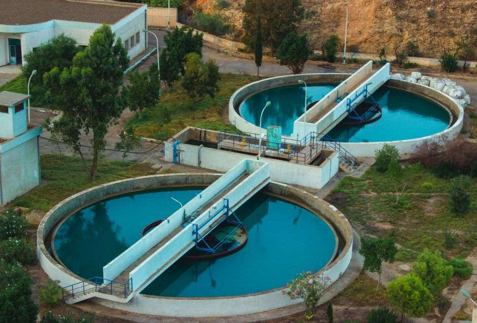 Aerial view of a wastewater treatment plant surrounded by trees