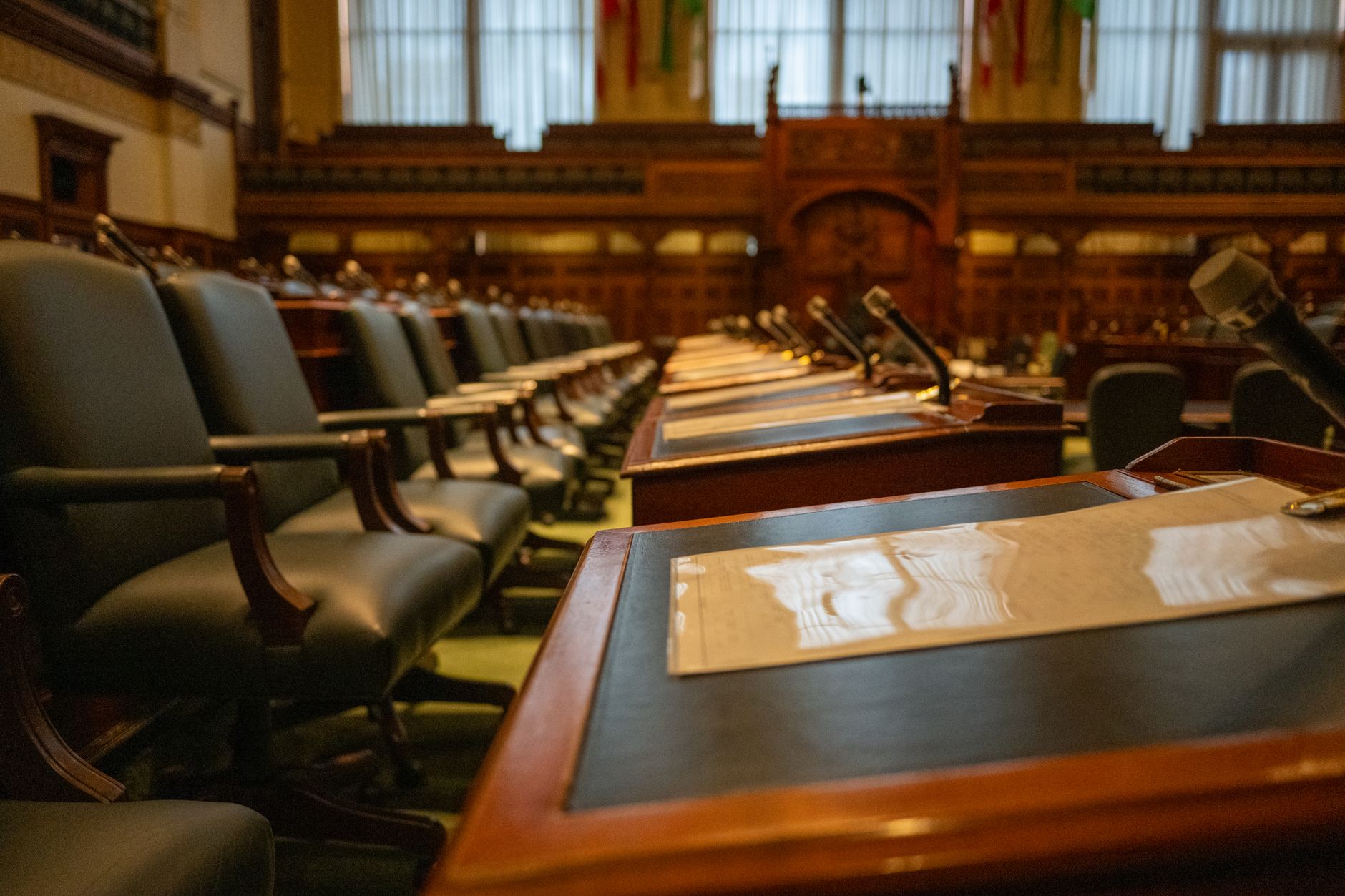 An empty city council chamber with seats and a dais