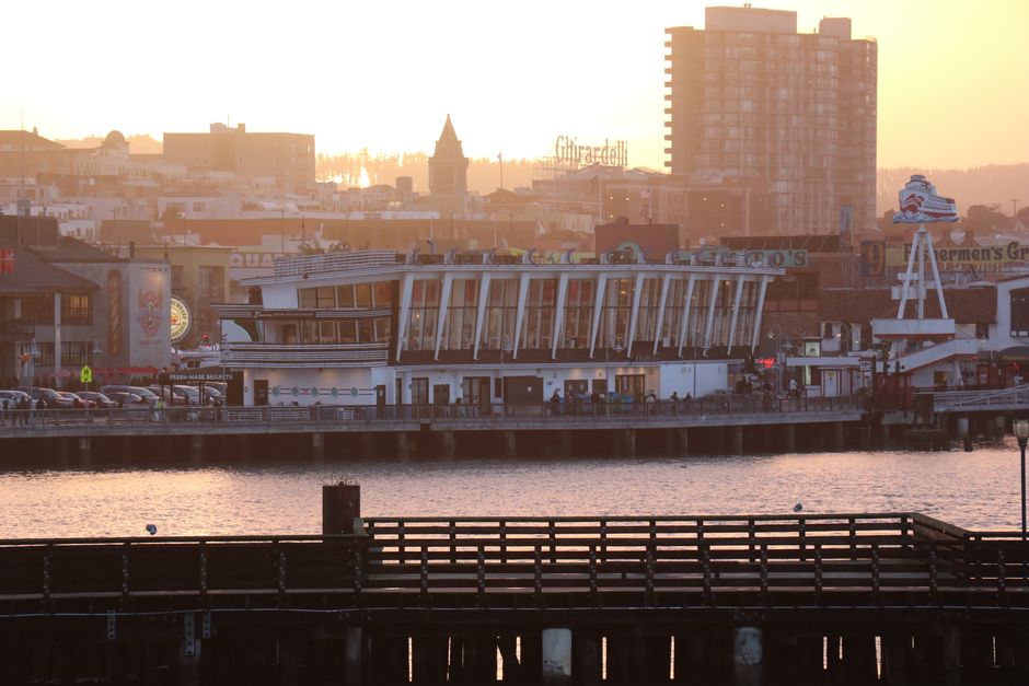 Restaurant on a pier overlooking the water at sunset
