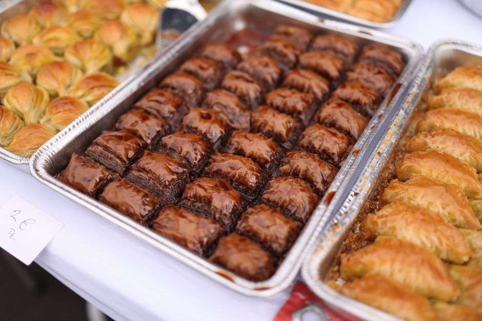 Trays of baklava and other Greek pastries prepared for a community festival