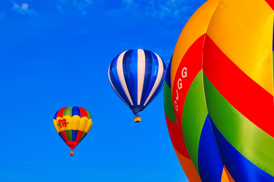 Colorful hot air balloons rising into the sky during a festival