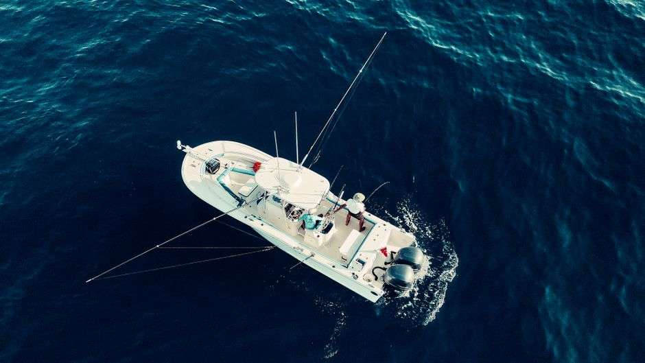 A fishing boat travels across open Gulf of Mexico waters with an angler aboard