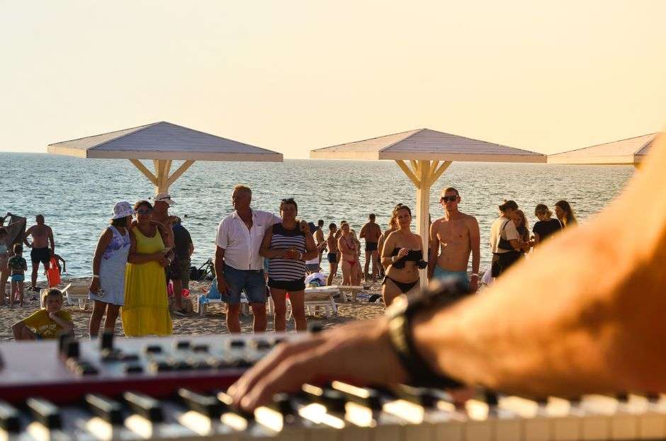 Musician performing outdoors at sunset near the beach