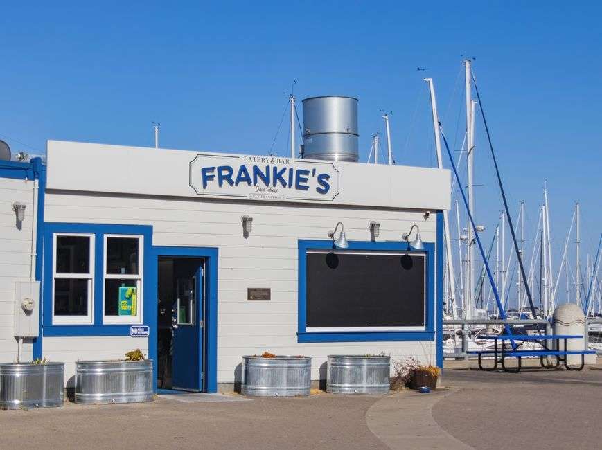Waterfront restaurant deck with tables overlooking a marina in Gulf Shores