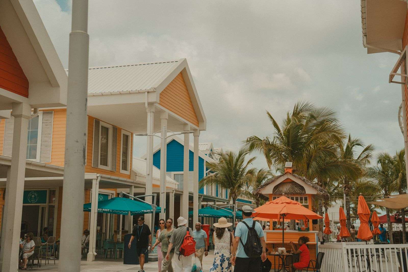 Colorful street lined with shops and palm trees on a sunny day