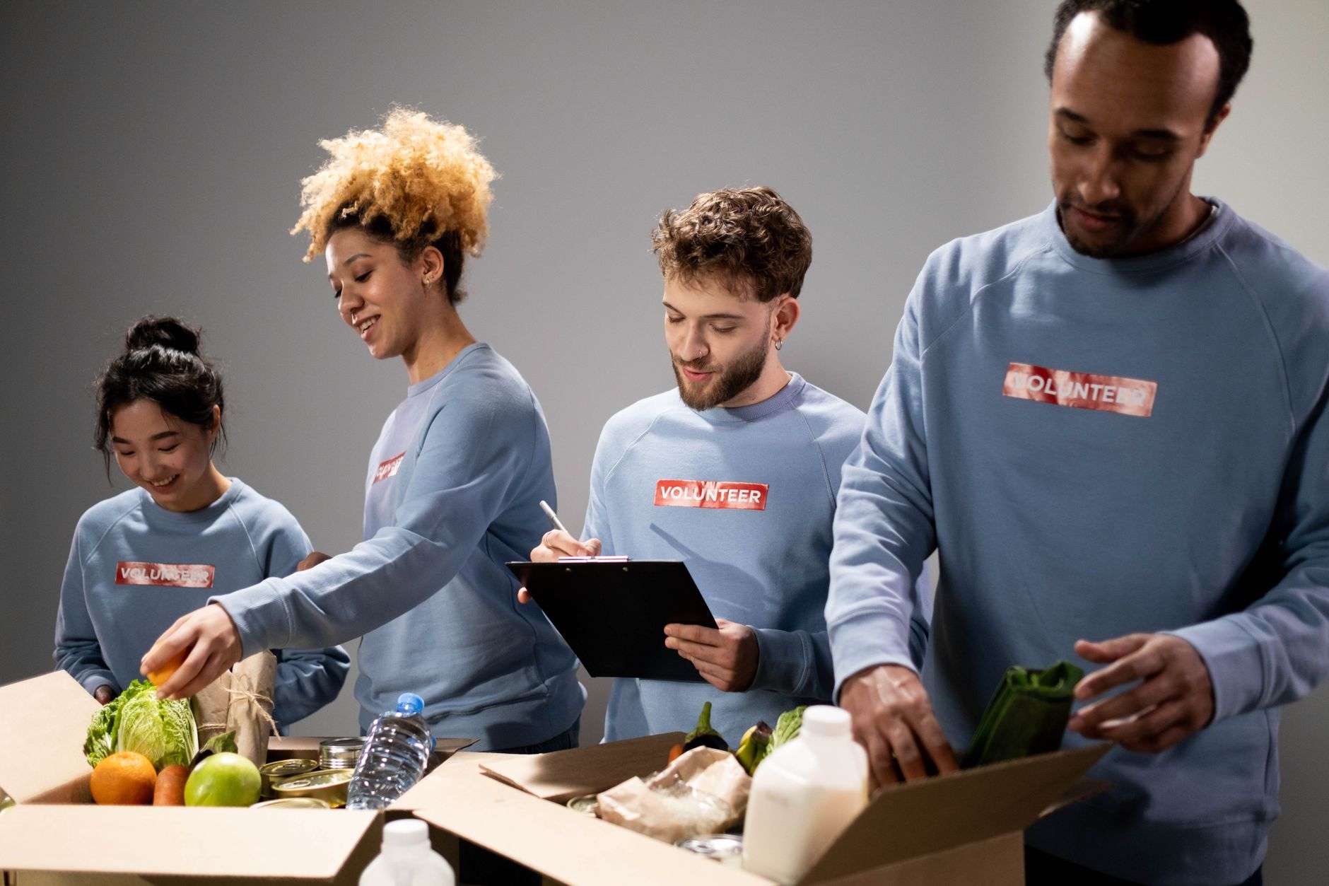 Volunteers sorting donated boxes of goods in a community service center