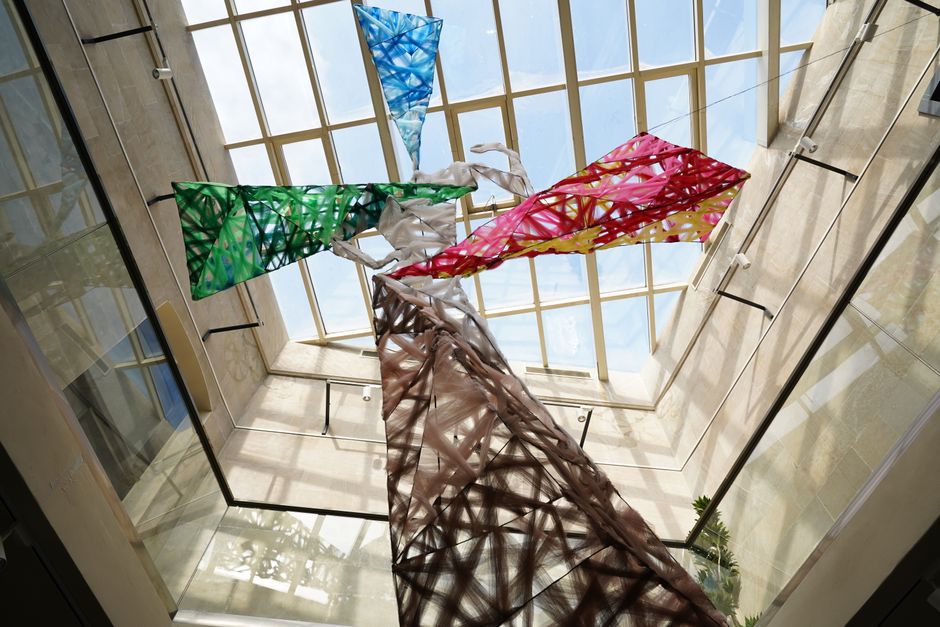 Large fabric art sculpture suspended in a museum rotunda