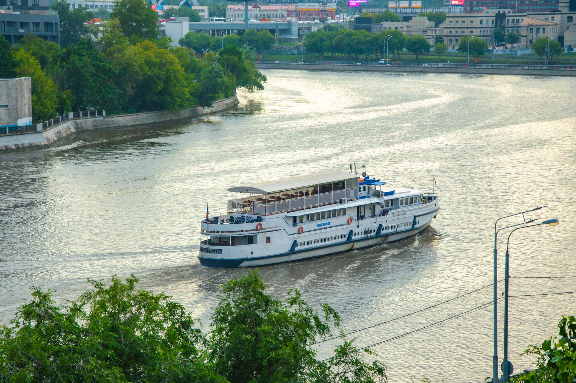A passenger excursion vessel cruising on a bay at dusk