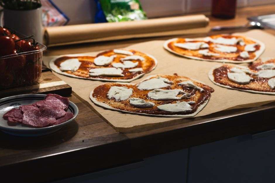 A heart-shaped pizza topped with cheese and toppings, prepared for a Valentine's Day special