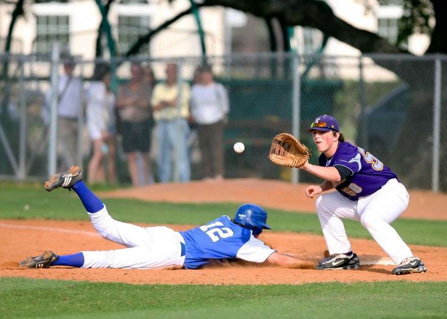 A high school baseball outfielder tracks down a fly ball during a game