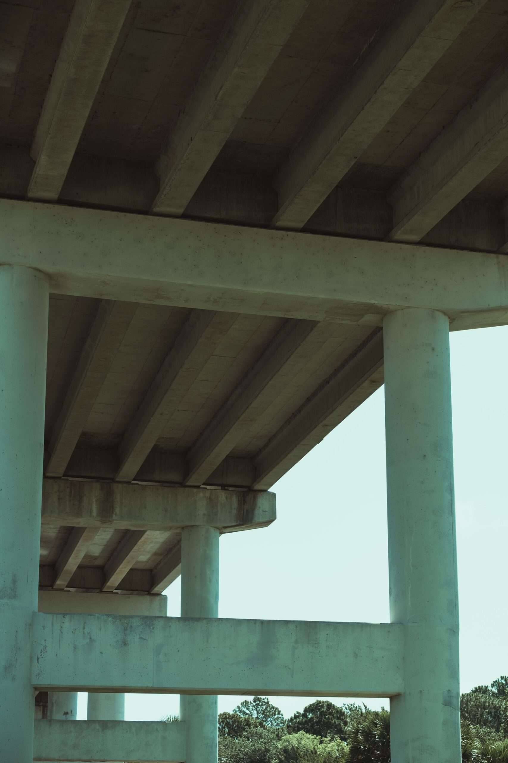 Low angle view of a concrete highway bridge showing support beams and columns against the sky