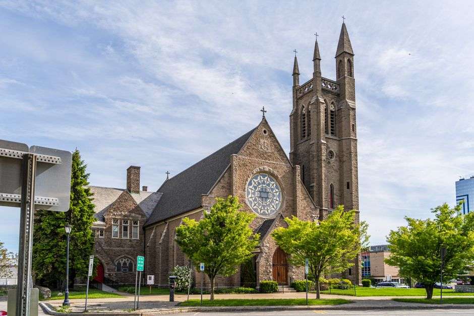 Exterior view of a historic downtown Catholic church with tall steeple