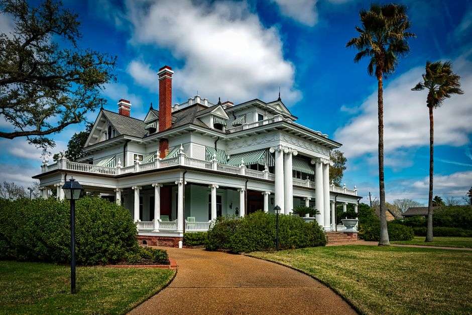 Historic antebellum-style mansion with columns and landscaped grounds