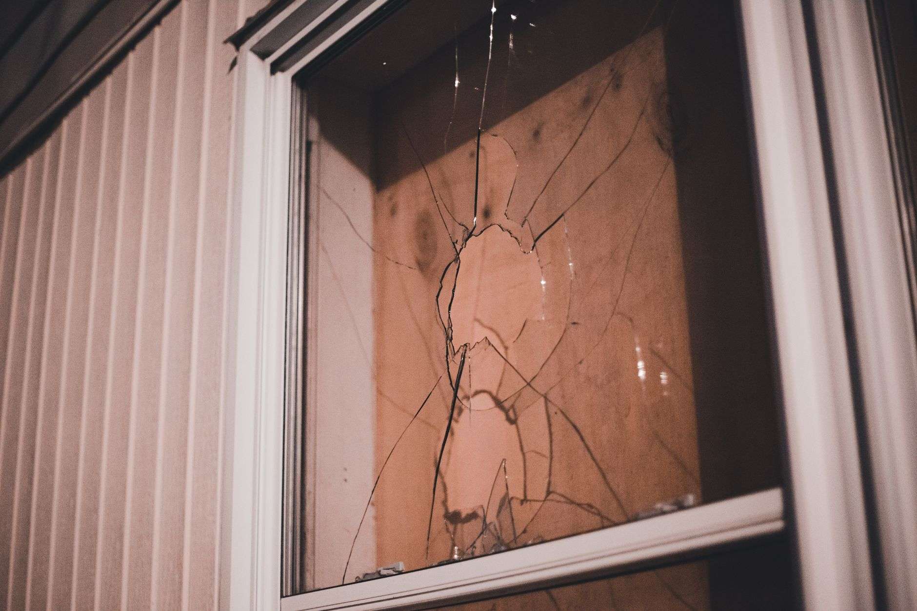 Cracked residential window pane photographed at night