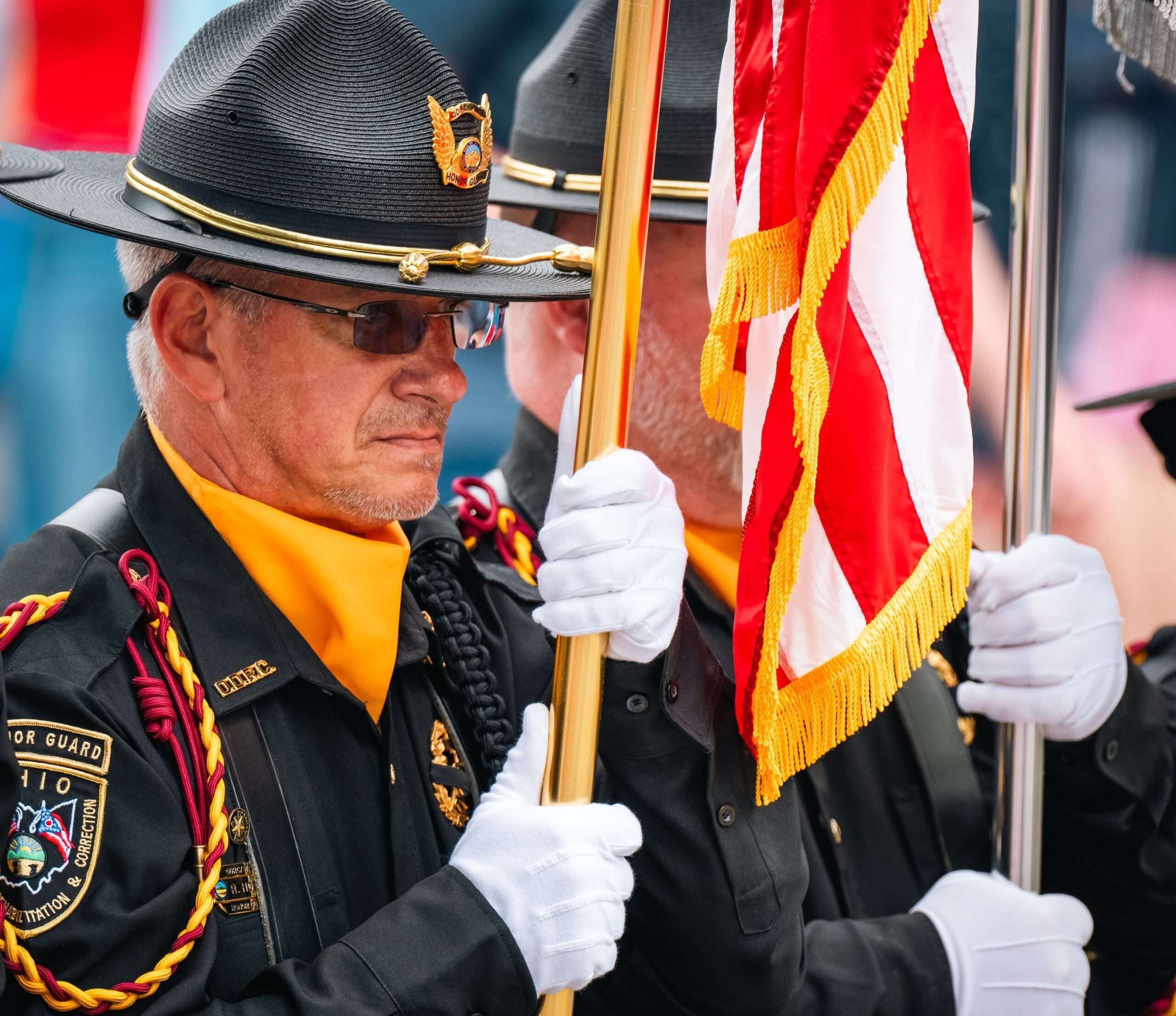 Military honor guard members holding an American flag during a ceremony