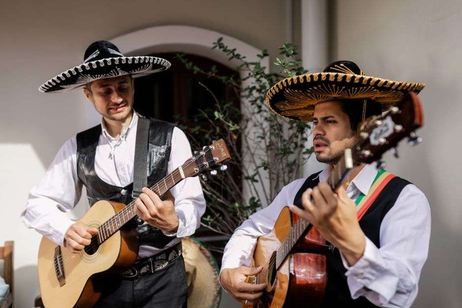Two acoustic musicians performing together on stage with guitars