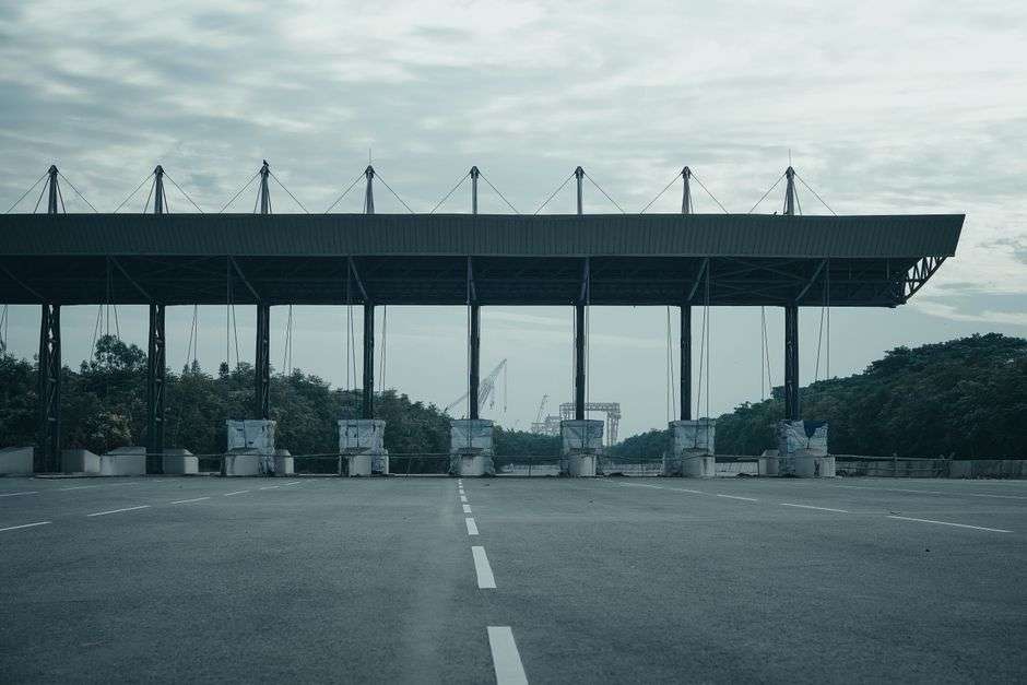 An empty toll gate on a highway leading toward a bridge crossing