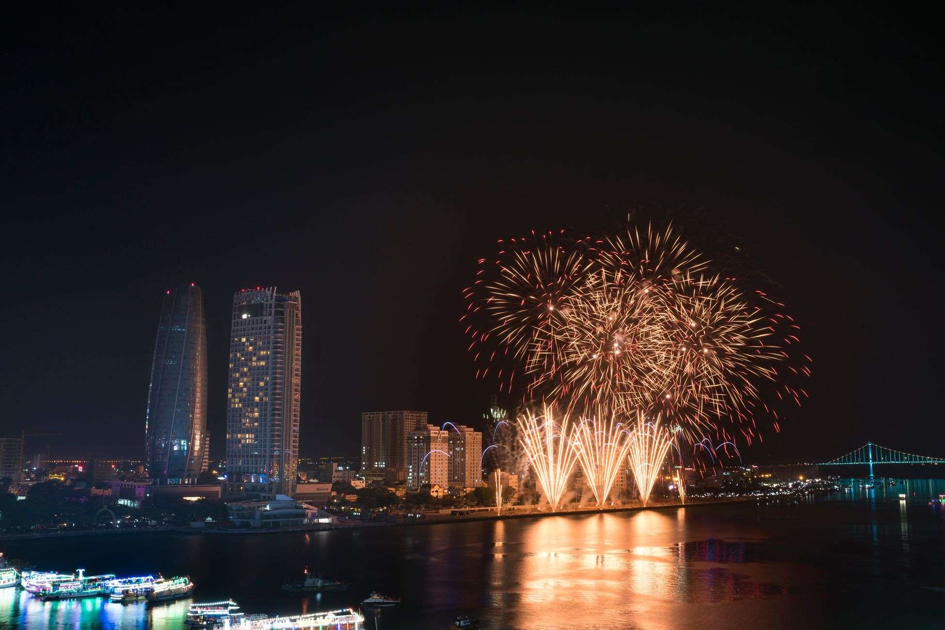 Fireworks light up the night sky over a downtown skyline during a New Year's Eve celebration