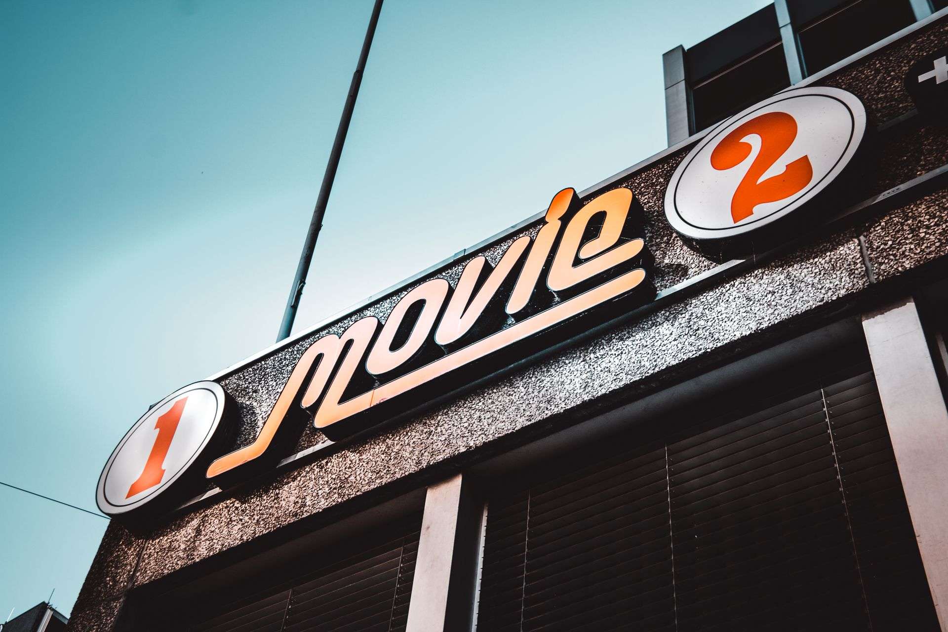Vintage movie theater marquee sign against a blue sky