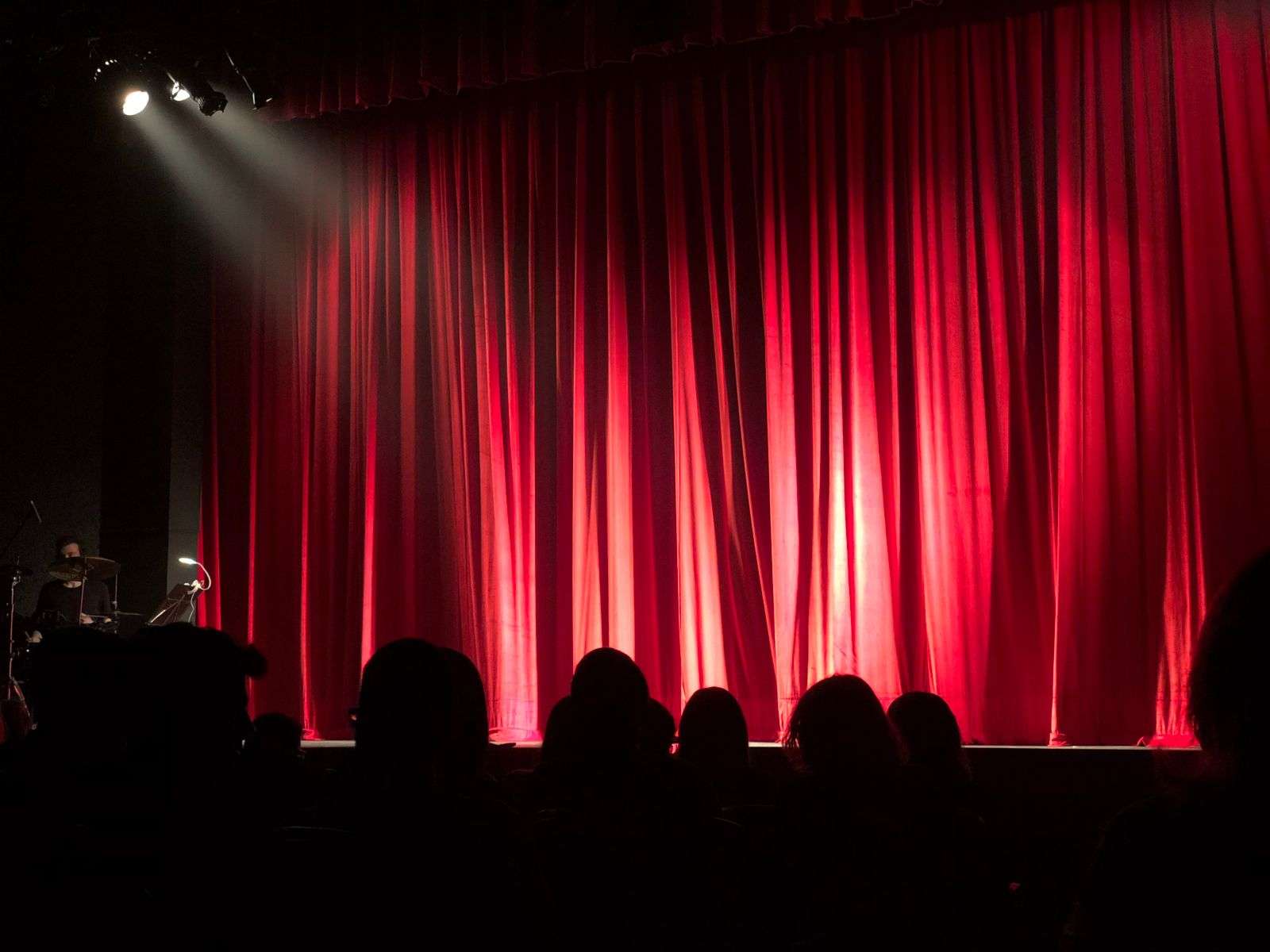 Empty theater stage with red curtains, set for a live performance