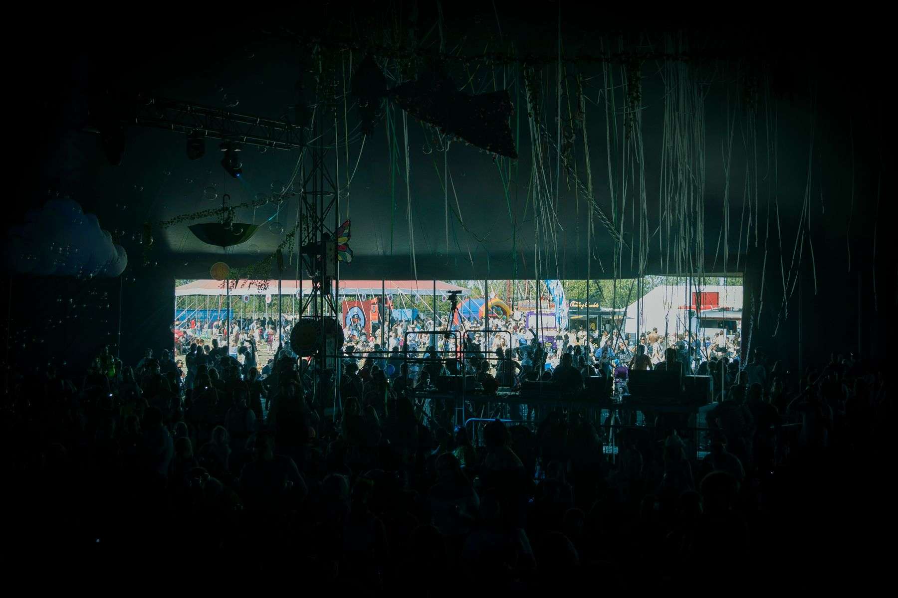 A large crowd gathers at an outdoor beach music festival stage