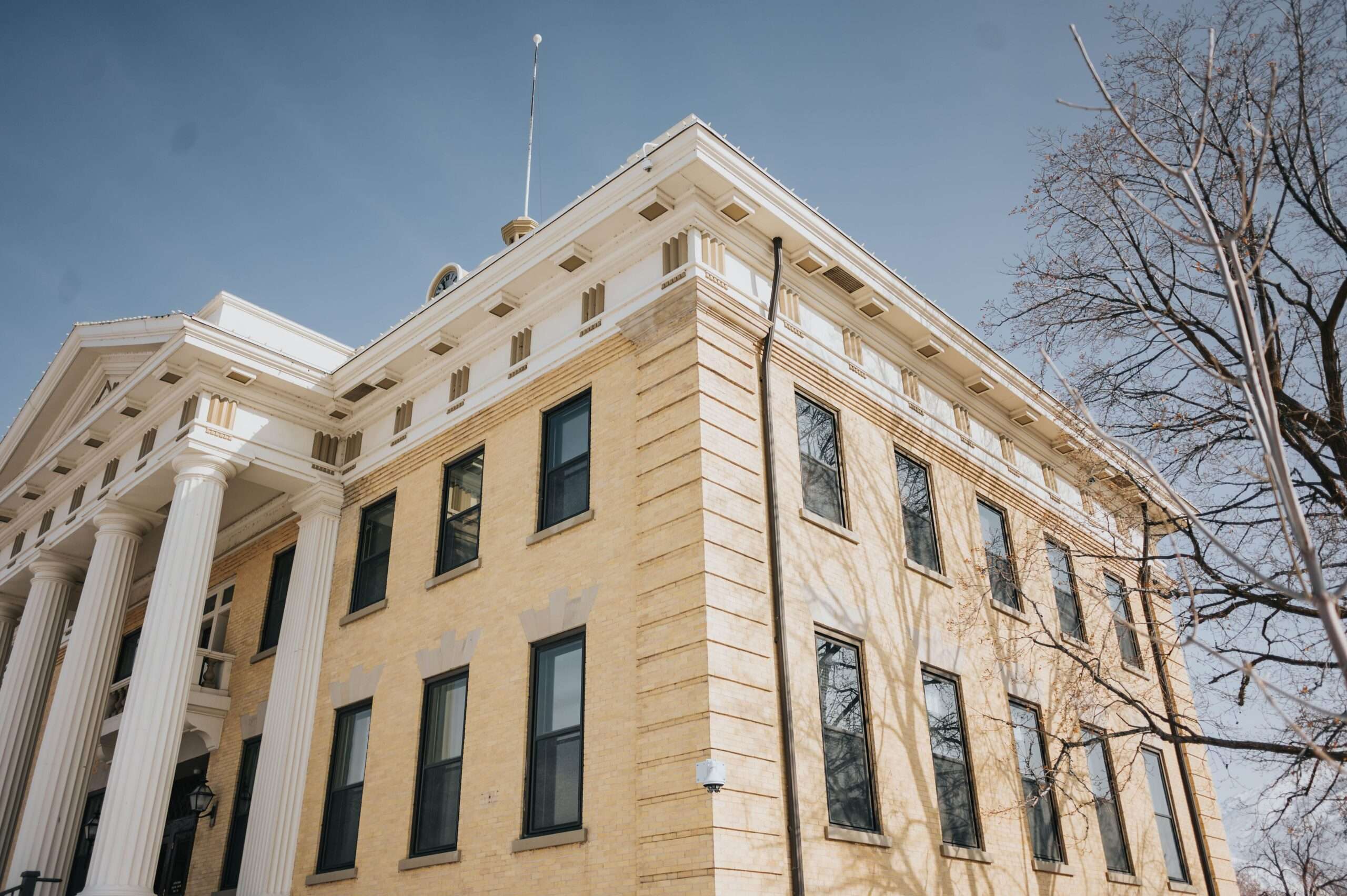 Classical courthouse columns beneath a blue sky