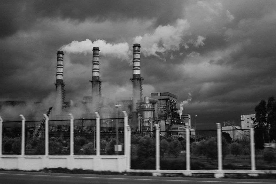 Industrial smokestacks releasing thick smoke into the sky
