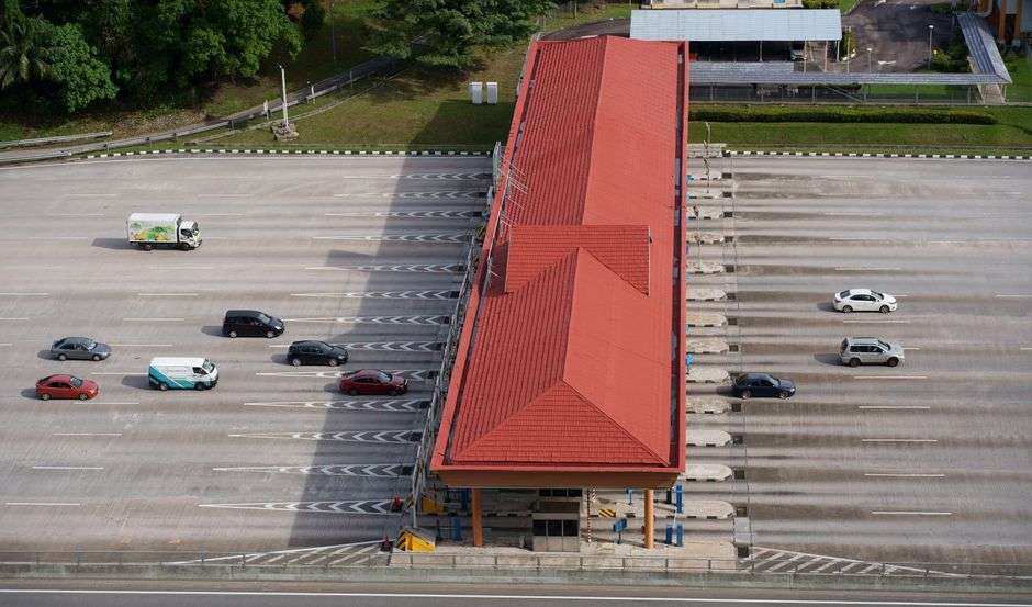 Aerial view of a multi-lane highway toll plaza with vehicles passing through