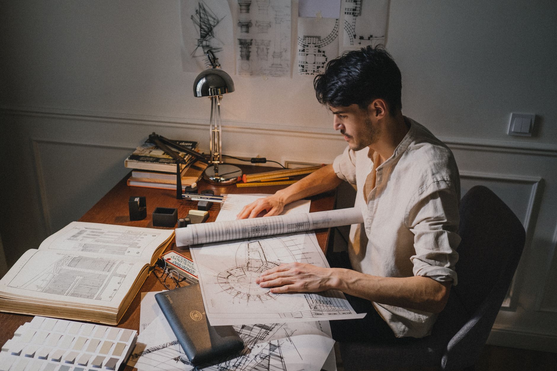 Rolled construction blueprints and building plans on a desk