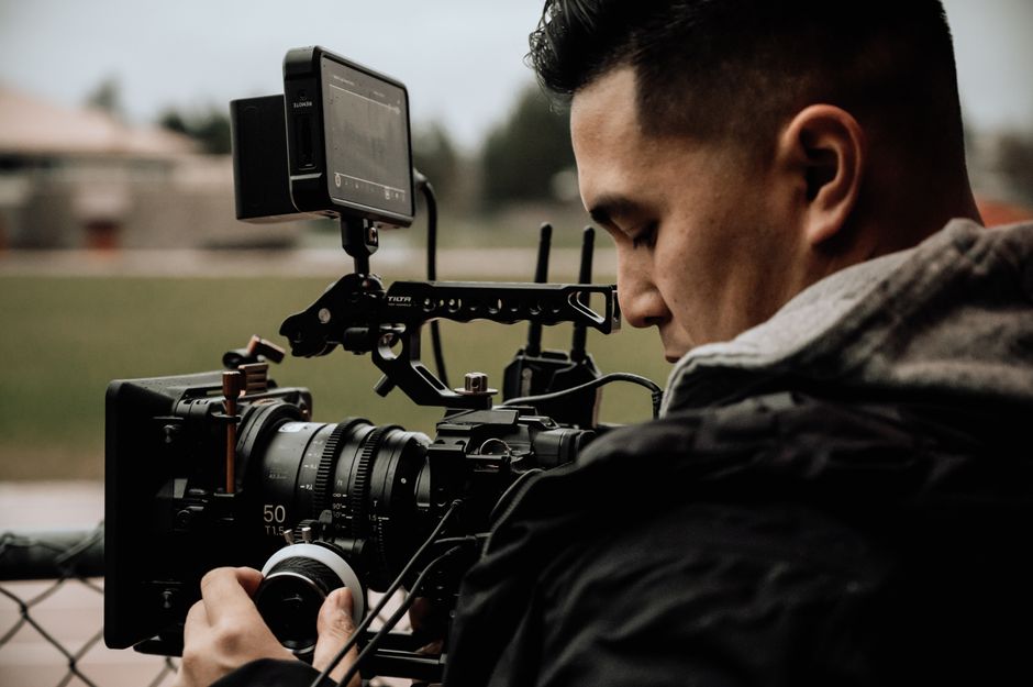 A filmmaker working with a camera on a production set