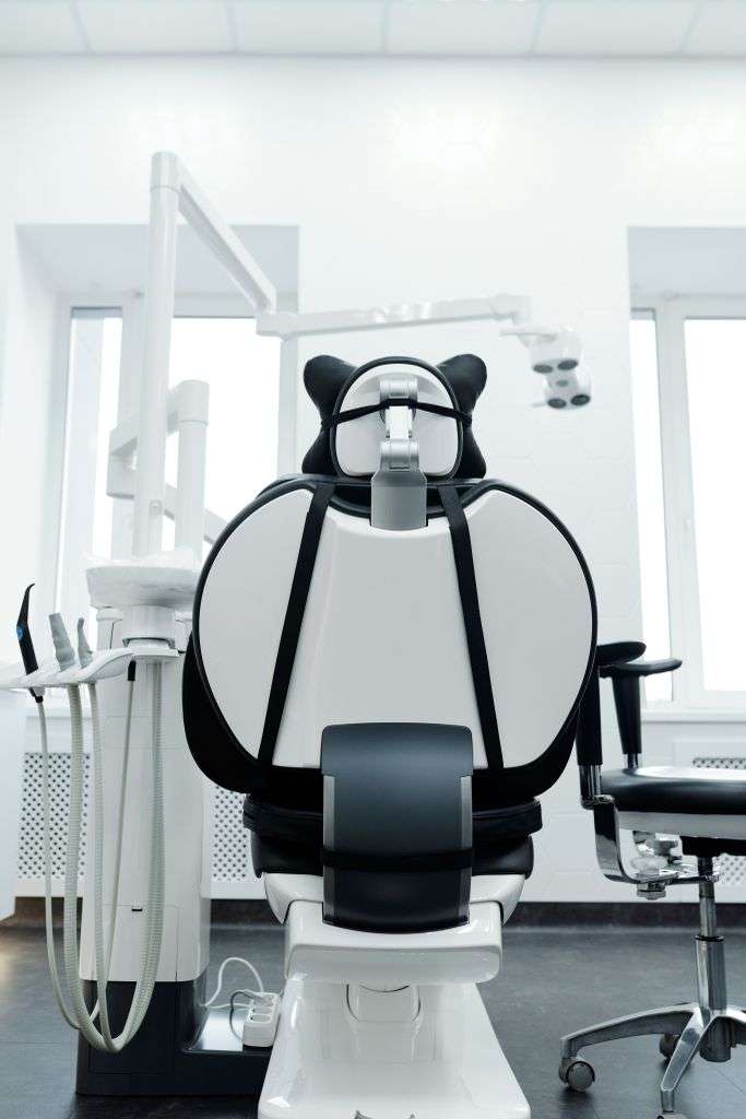 Bright, modern dental clinic room with a dental chair and equipment
