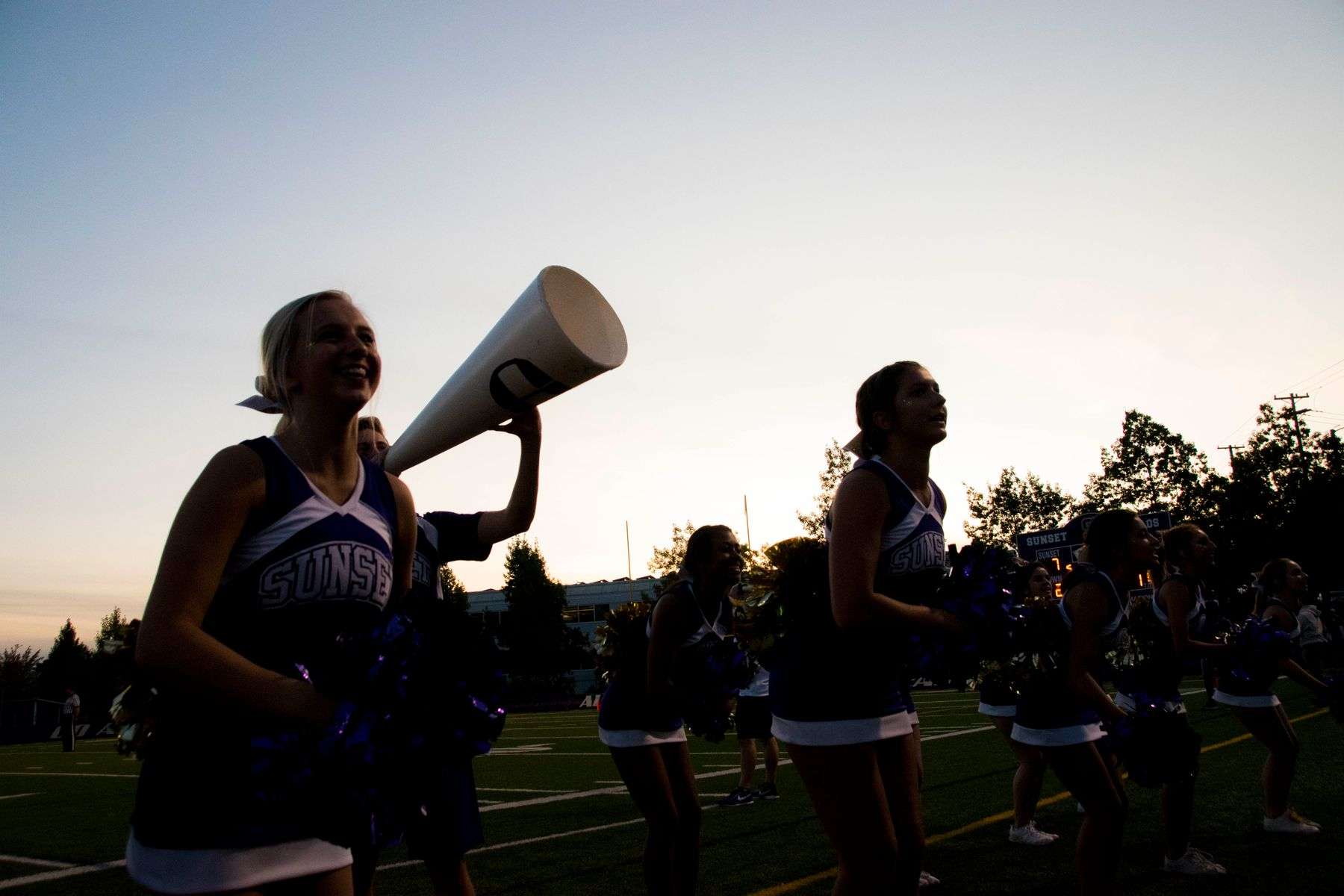 Cheerleaders and fans celebrate school spirit at an outdoor community pep rally