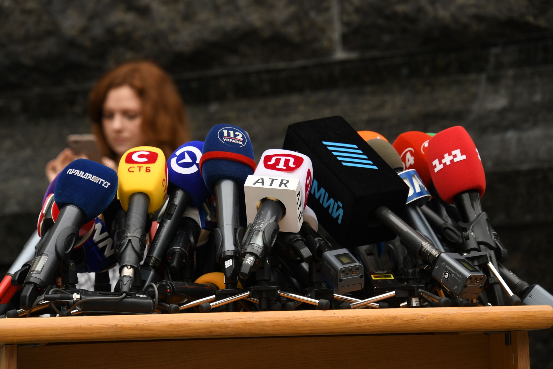 A candidate announcing at a podium before microphones