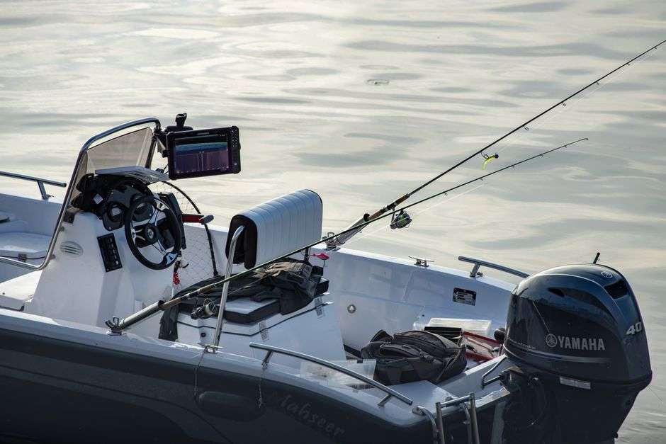 A fishing boat loaded with rods and tackle sits on calm water ahead of a charity fishing tournament