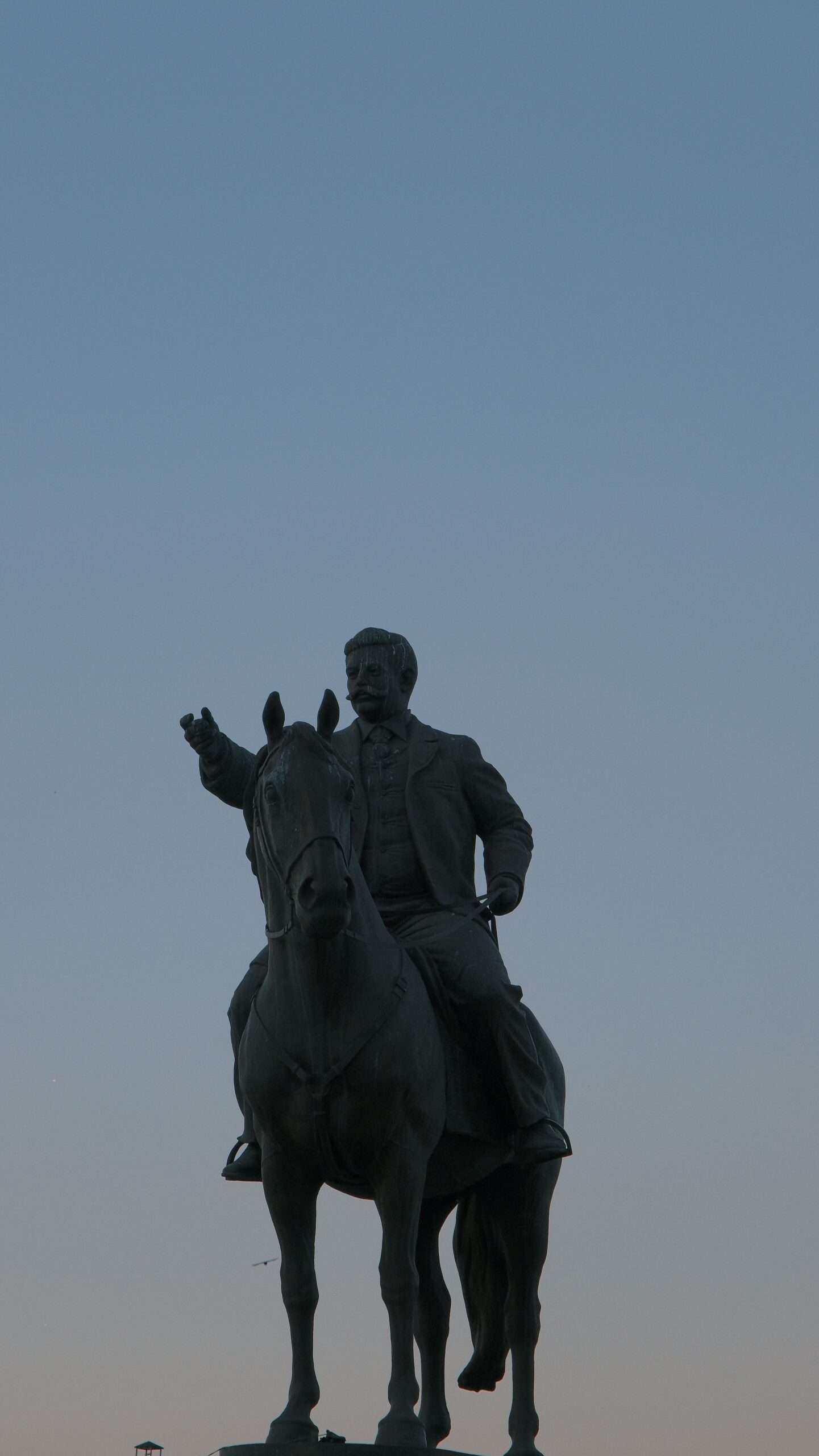 A bronze horse statue mounted on a pedestal against a clear blue sky, representing restored public art on display outdoors
