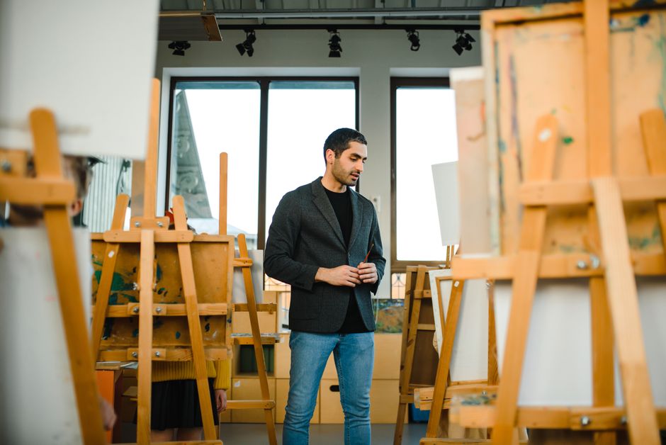 An artist painting a portrait in a studio setting